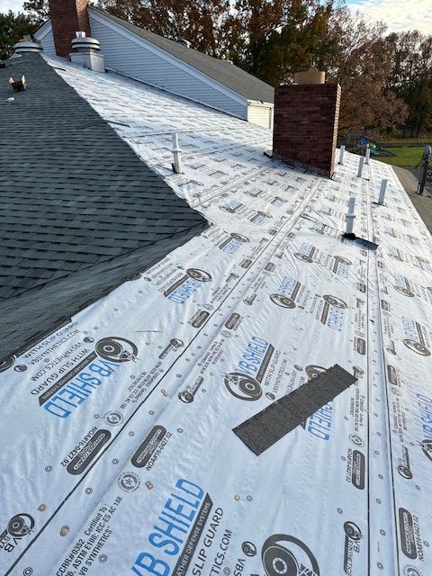 The roof of a house is being covered with a roof shield.
