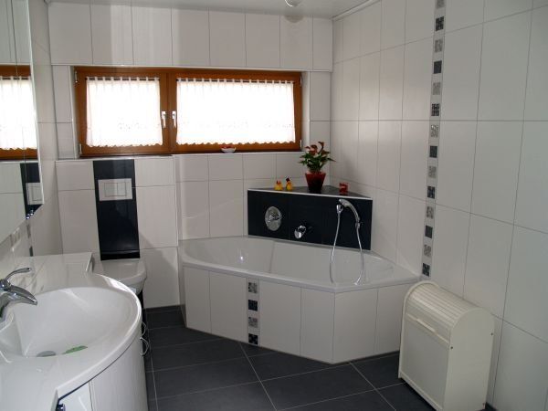 Ein Badezimmer mit Eckbadewanne und Waschbecken