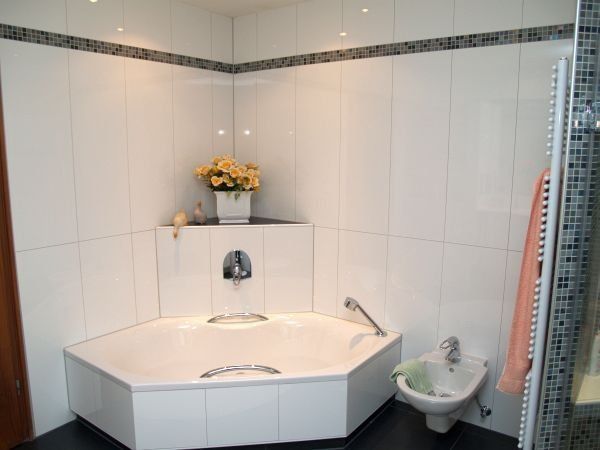 Ein Badezimmer mit Eckbadewanne und Waschbecken