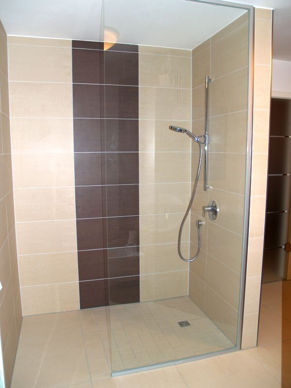 Ein Badezimmer mit ebenerdiger Dusche mit Glastür