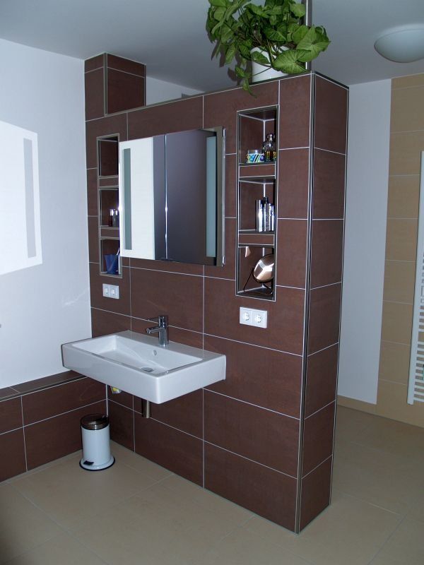 Ein Badezimmer mit Waschbecken und Spiegel an der Wand