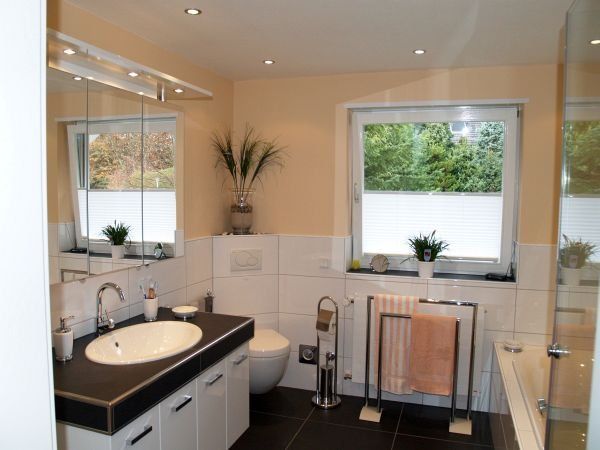 Ein Badezimmer mit Waschbecken, Toilette und Fenster