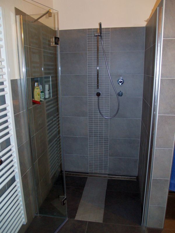 Ein Badezimmer mit ebenerdiger Dusche und Handtuchhalter