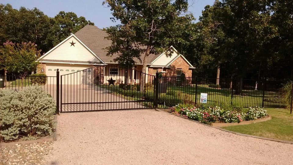 A house with a fence and a gravel driveway
