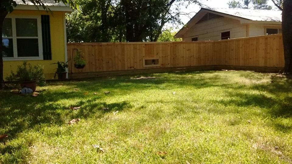 There is a wooden fence in the backyard of a house.