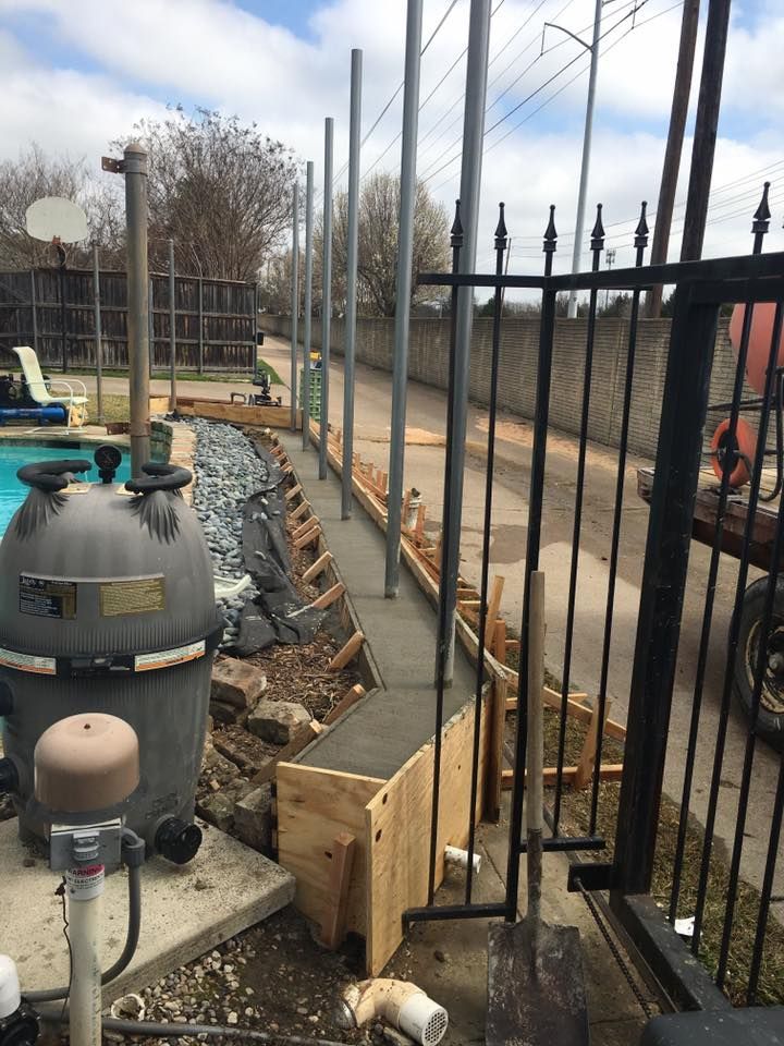 A fence is being built around a swimming pool.