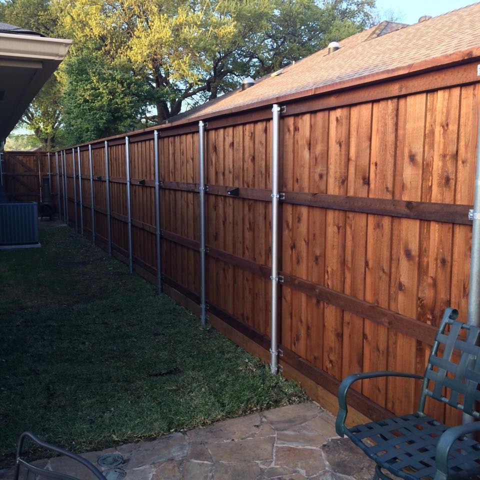 A wooden fence with a chair in front of it