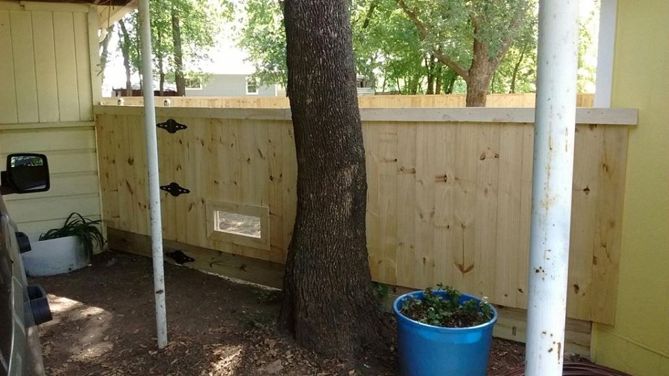 A wooden fence with a tree in the middle of it