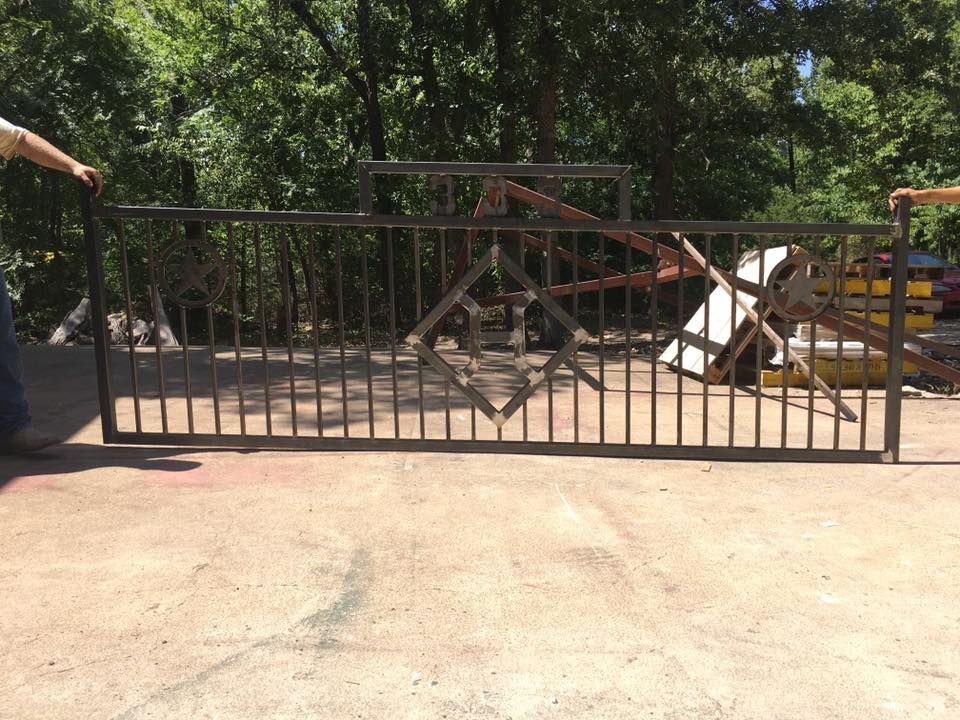 A man is standing next to a large metal gate