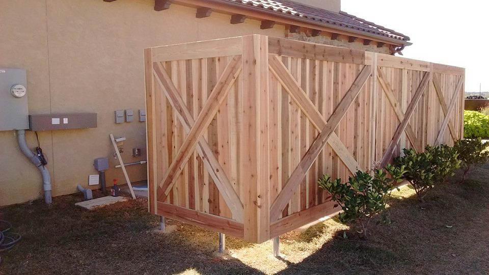 A wooden fence is being built in front of a house.