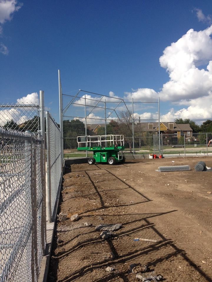 A chain link fence is surrounding a baseball field