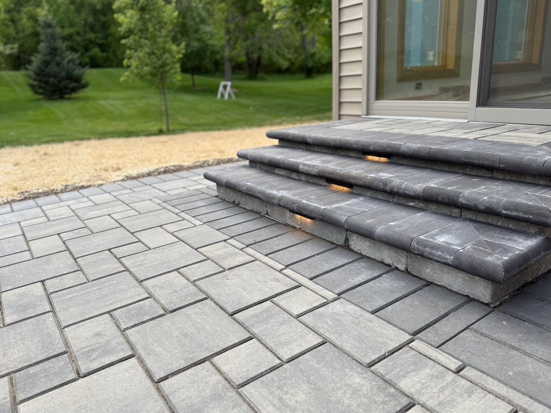 A patio with a table and chairs and a playground in the background