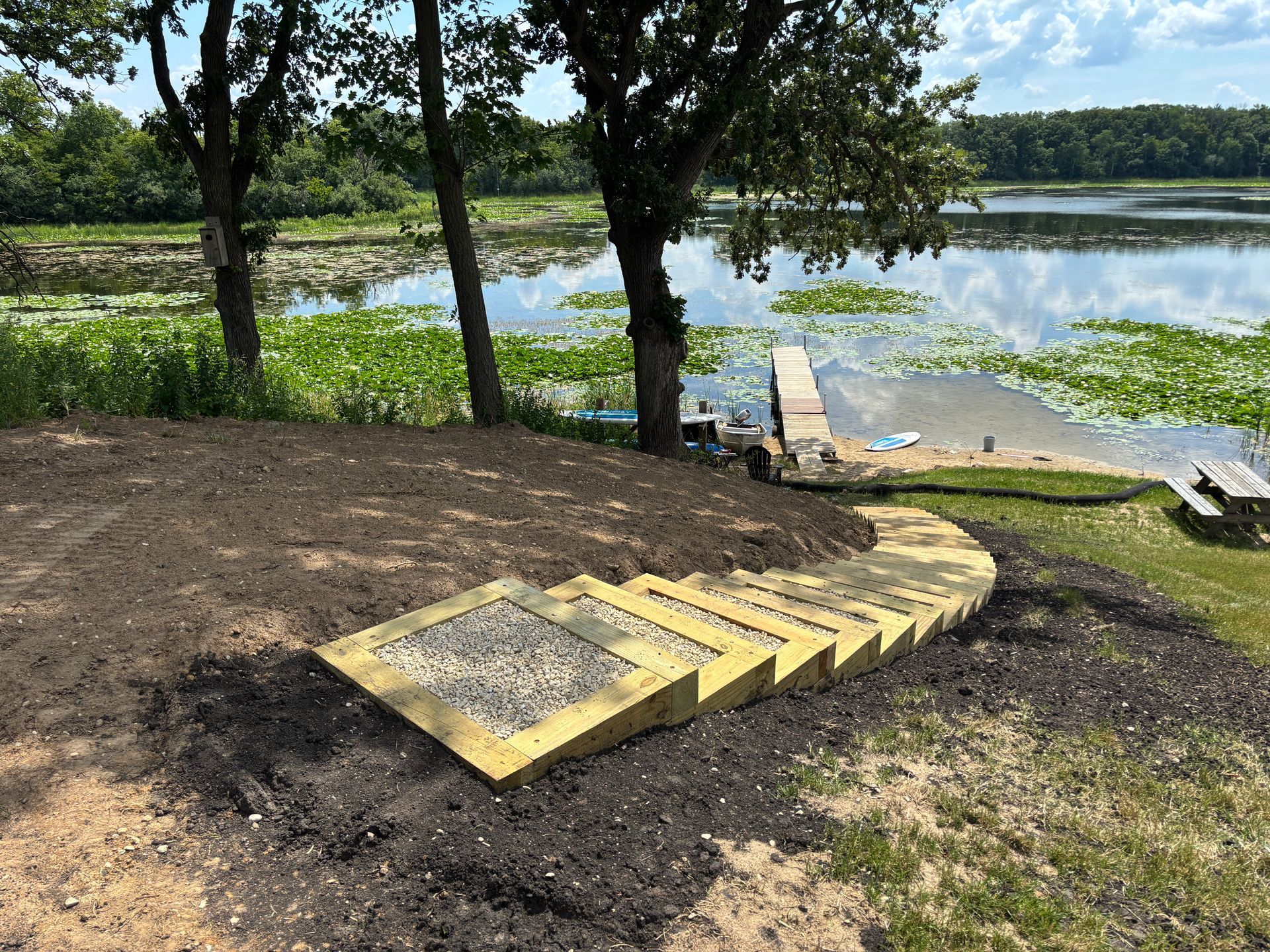 A backyard with a white fence and a rock garden.