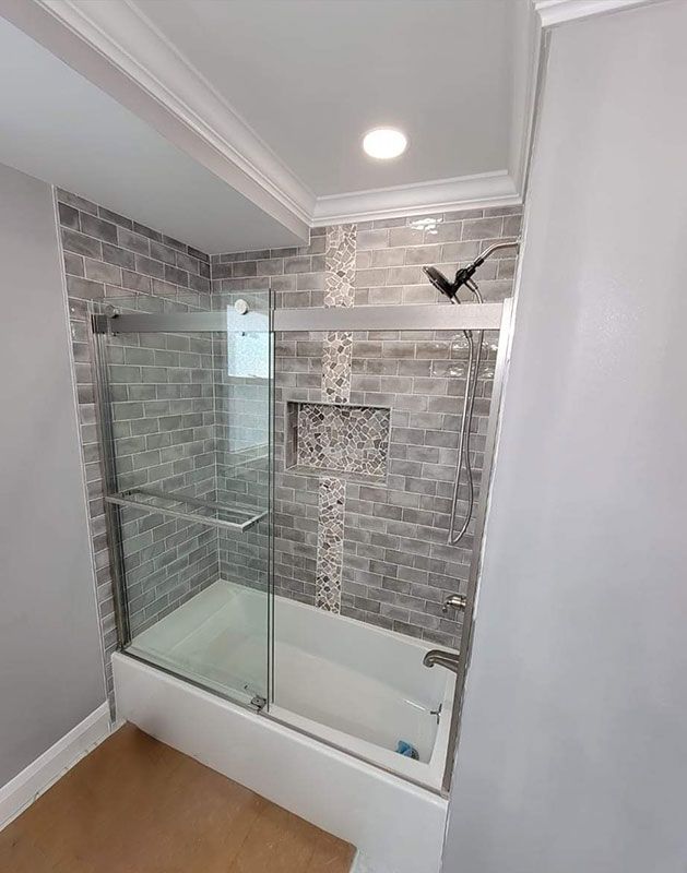 Modern bathroom with gray brick tile and a glass shower door.