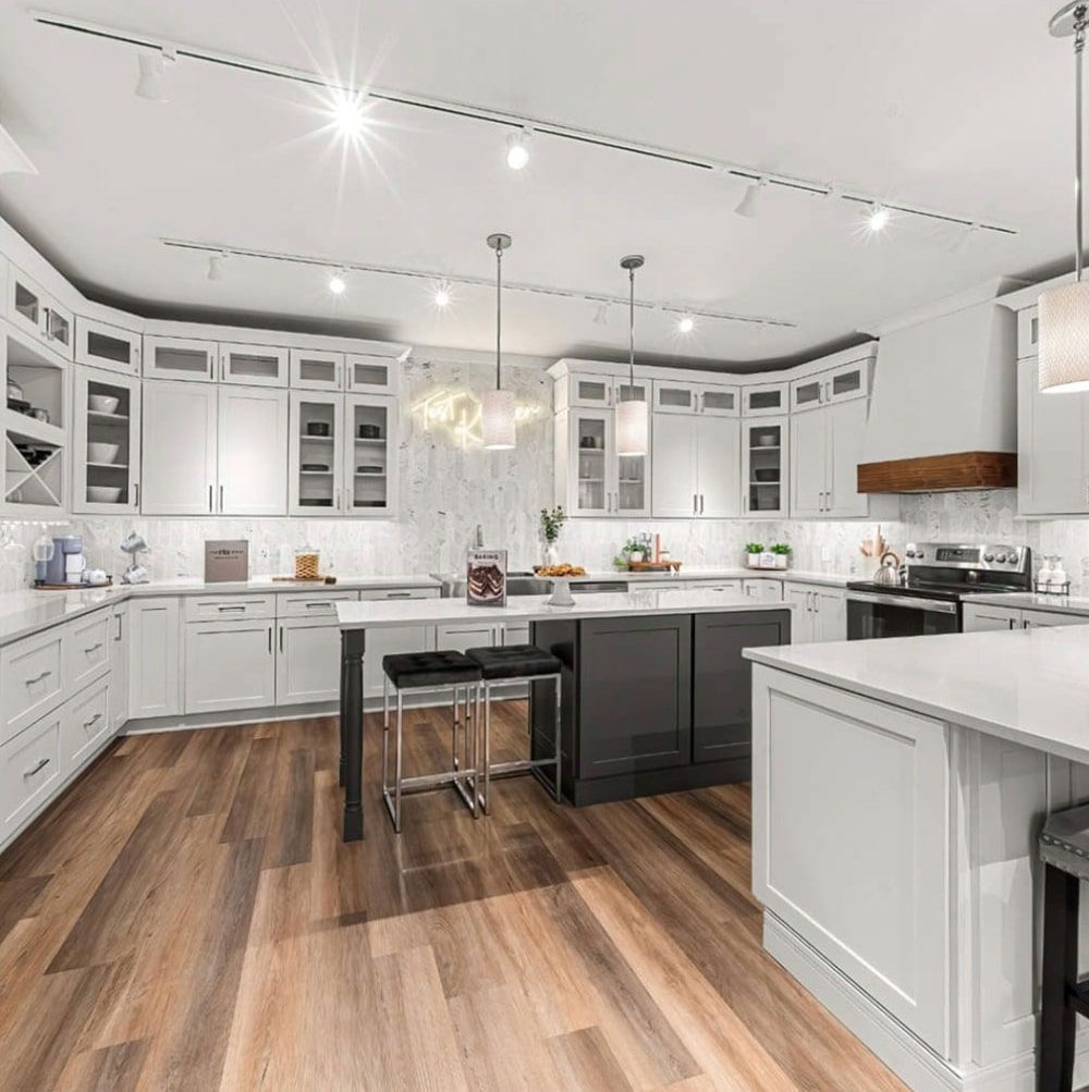 Modern white and gray kitchen with wood floor and an island.
