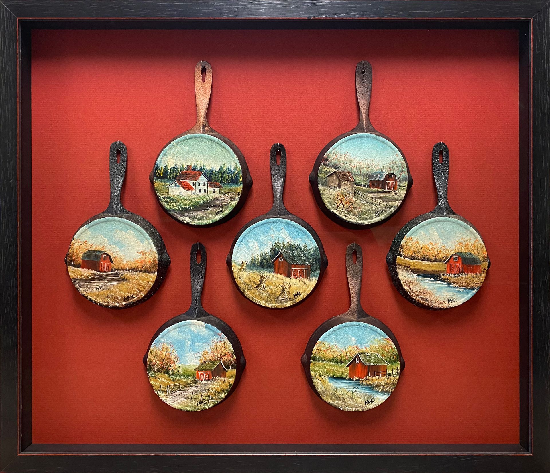 A framed set of pans with paintings on them