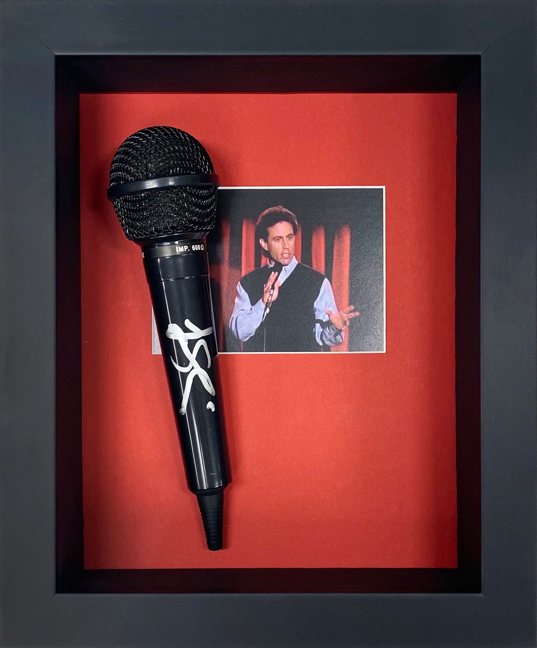 A framed microphone with a picture of a man behind it