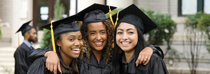 Three female graduates are posing for a picture together.