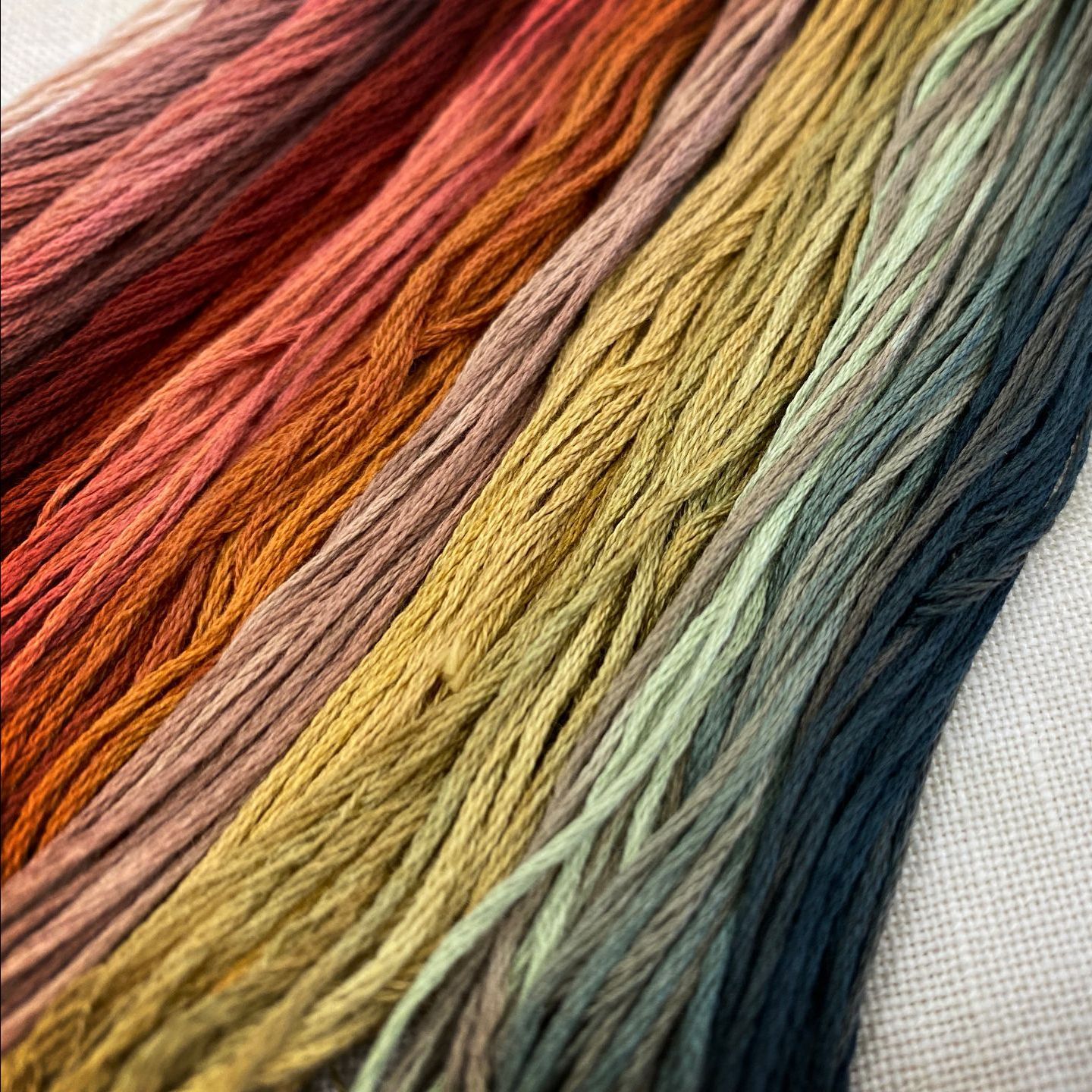 A close up of a bunch of different colored yarn on a table.
