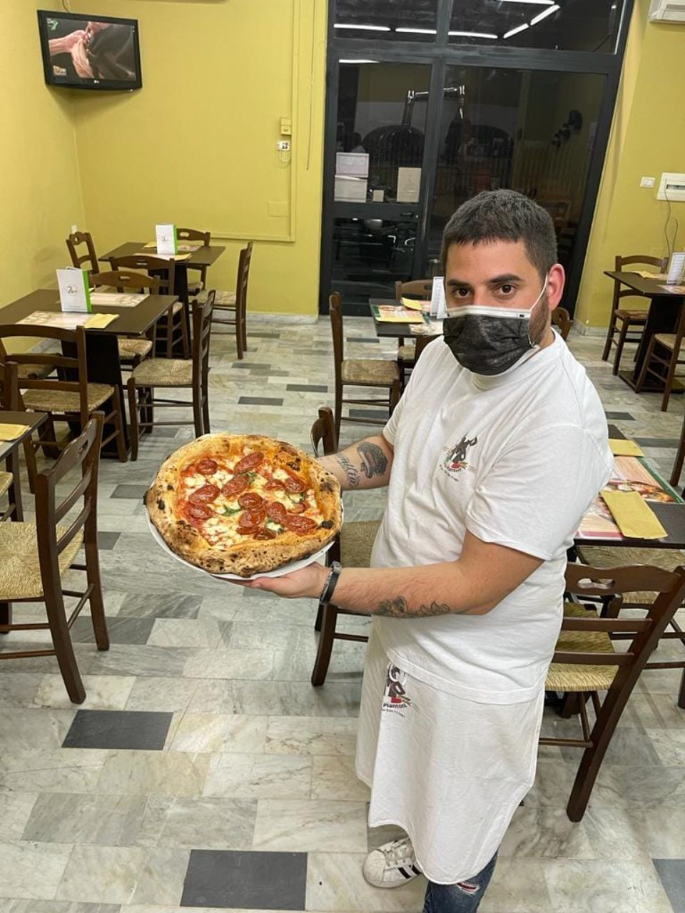 pizzaiolo mostra la sua pizza