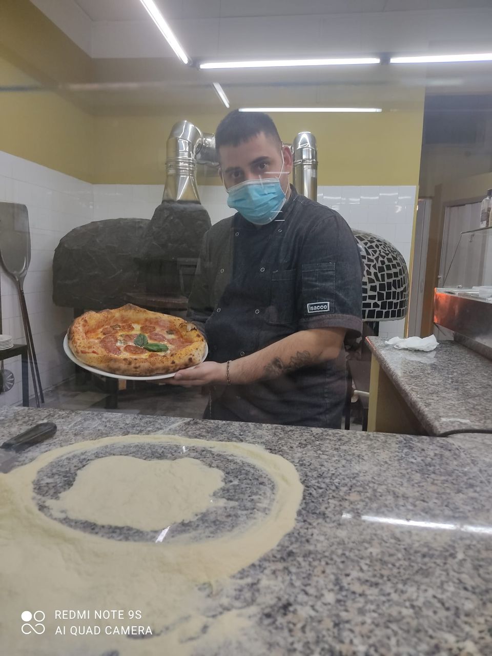 pizzaiolo con pizza appena sfornata