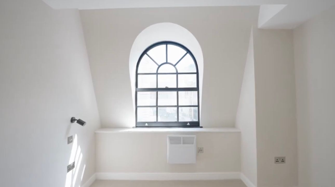 An empty room with a large window in the corner