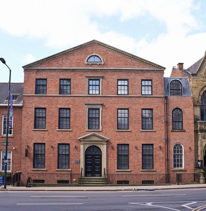 A large brick building with many windows and a door