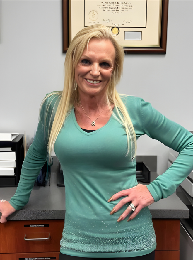 A smiling doctor in a lab coat with a stethoscope around his neck.