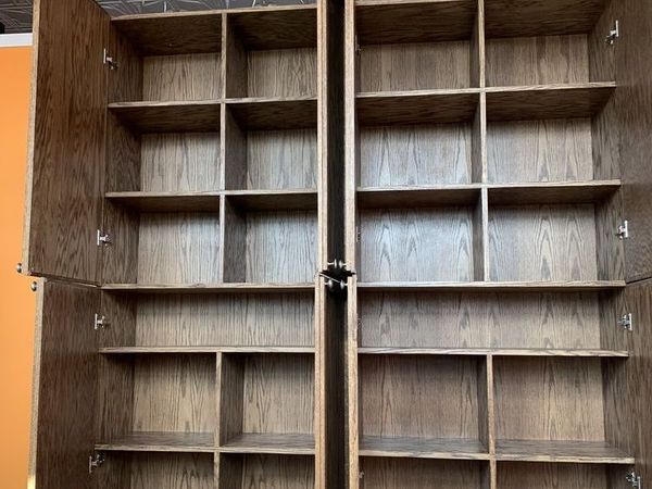 Wooden cabinet with open doors, revealing multiple shelves and compartments.