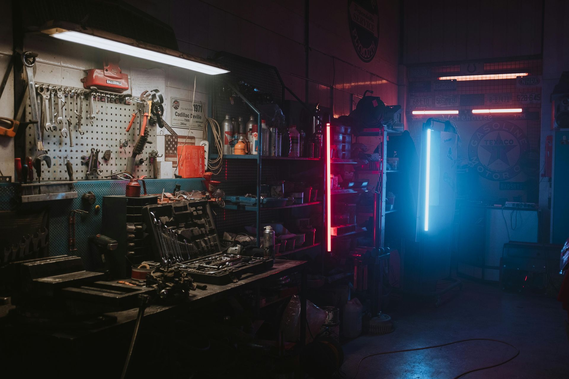 Dark garage with tools, workbench, and neon lights (red and blue).