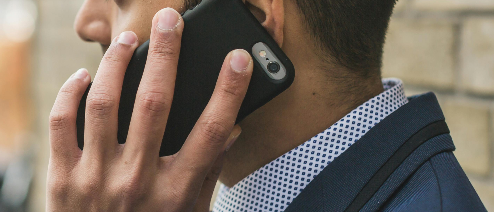 A man in a suit is talking on a cell phone.