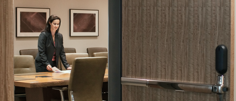 A woman is standing at a table in a conference room.