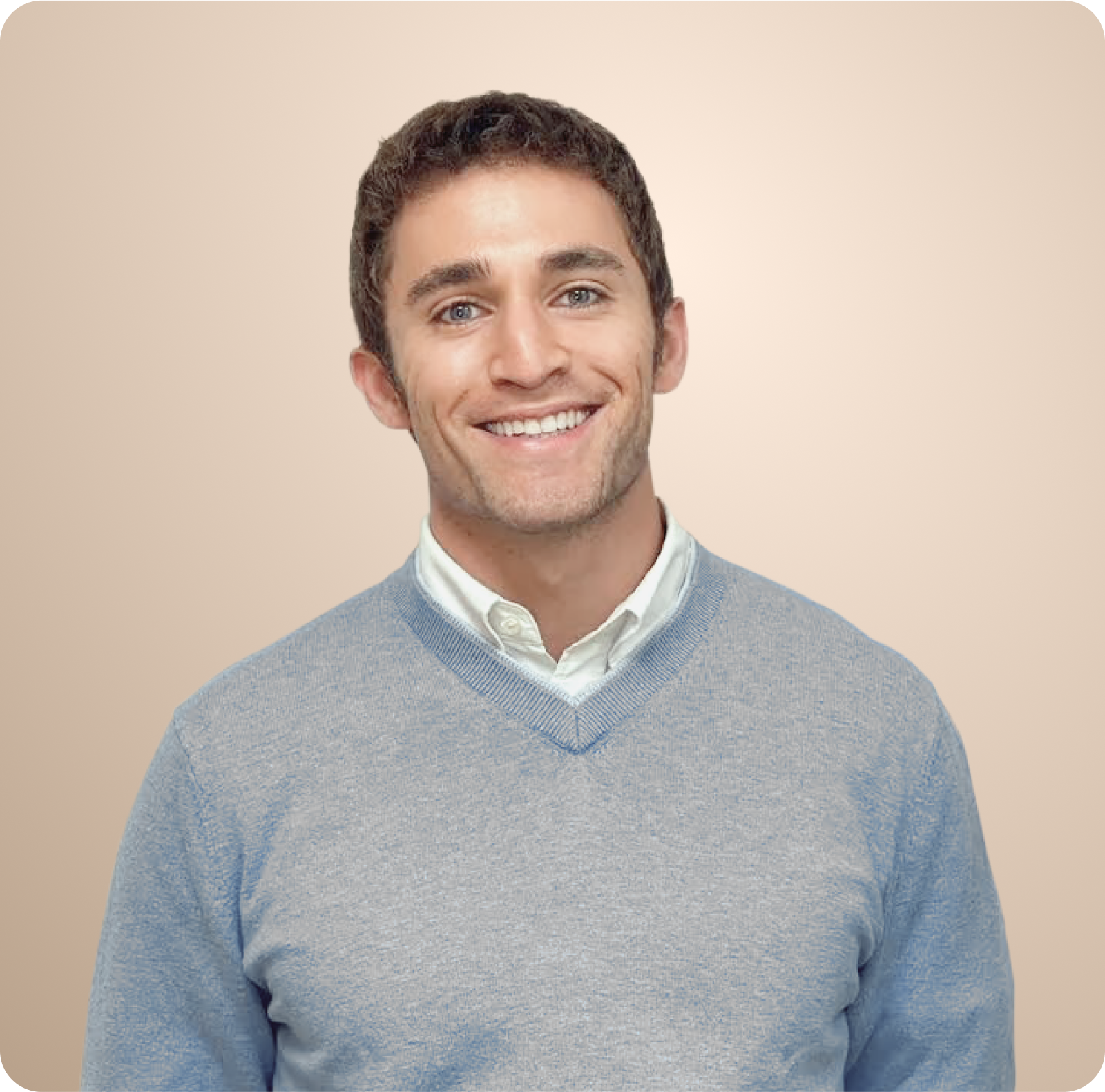 A man in a grey sweater is smiling for the camera
