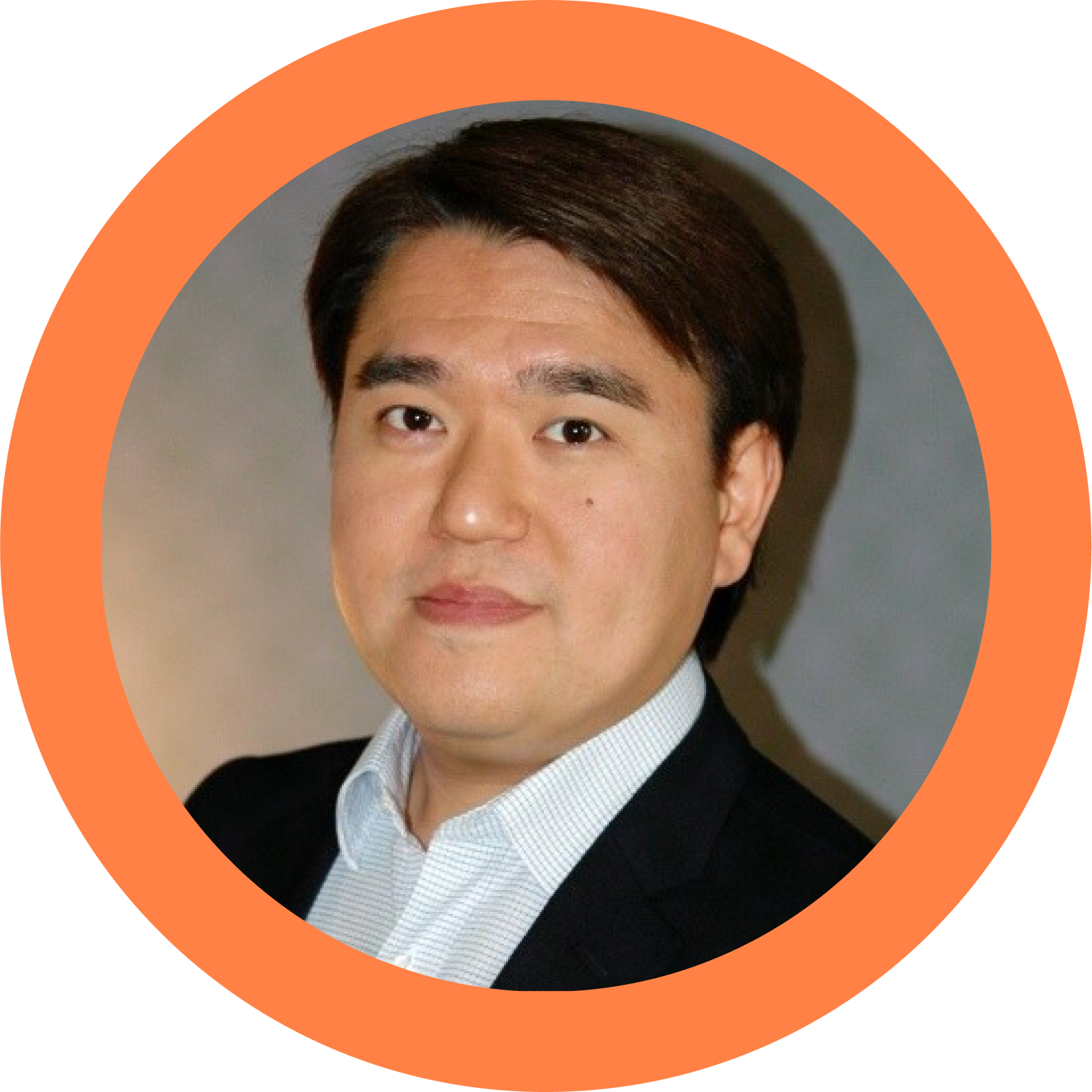 A man in a suit and white shirt is in an orange circle