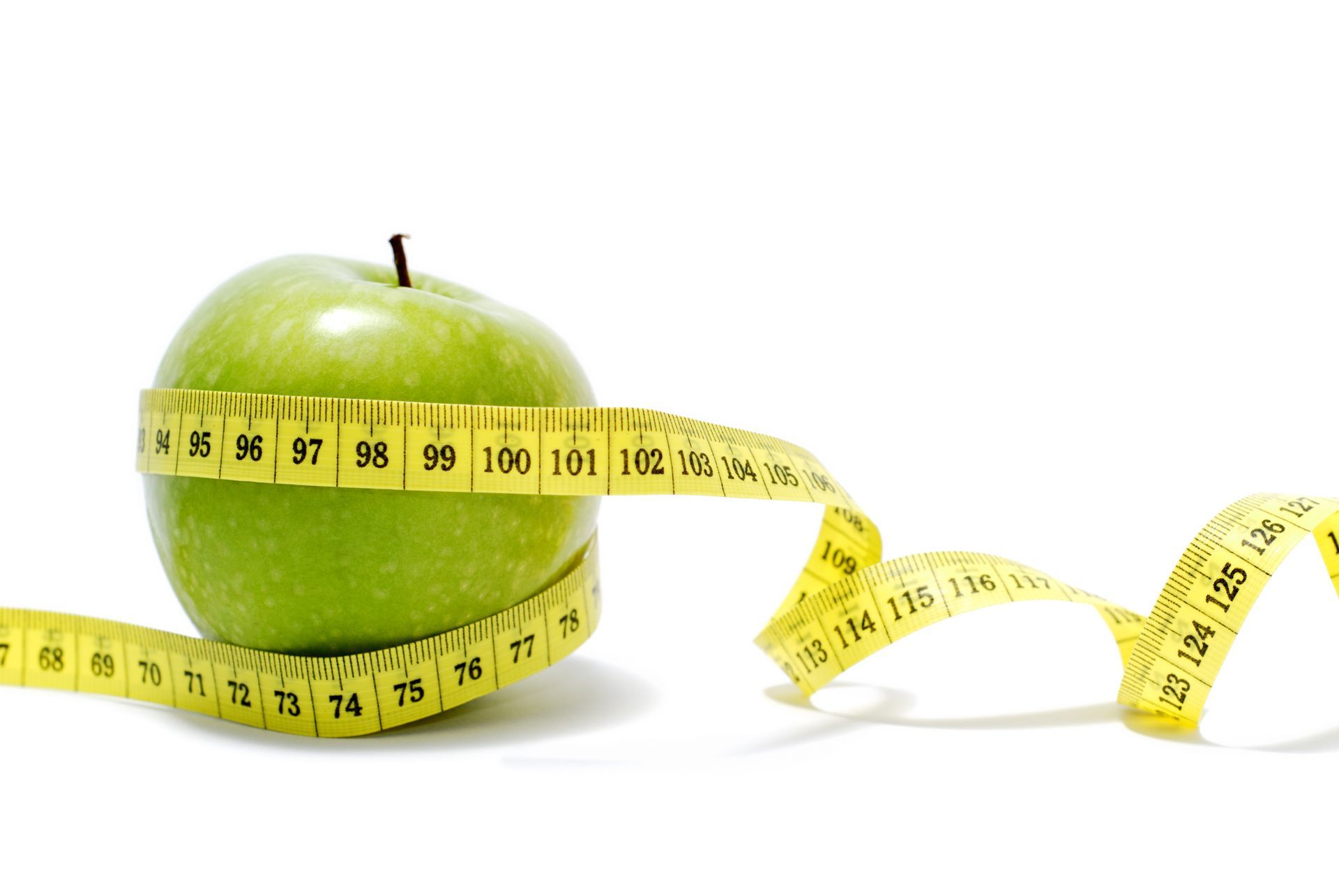 Close-up of a green apple with measuring tape around, symbolizing weight loss medical spa services.