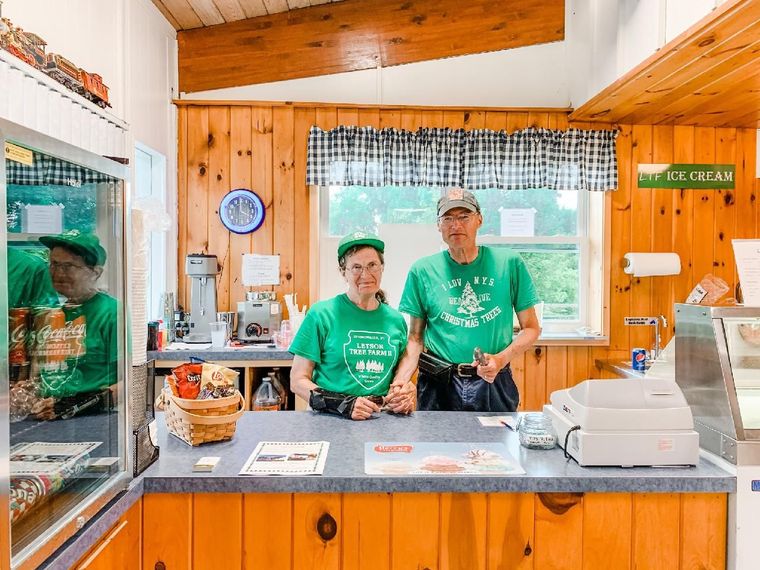A man and a woman are standing behind a counter in a restaurant.