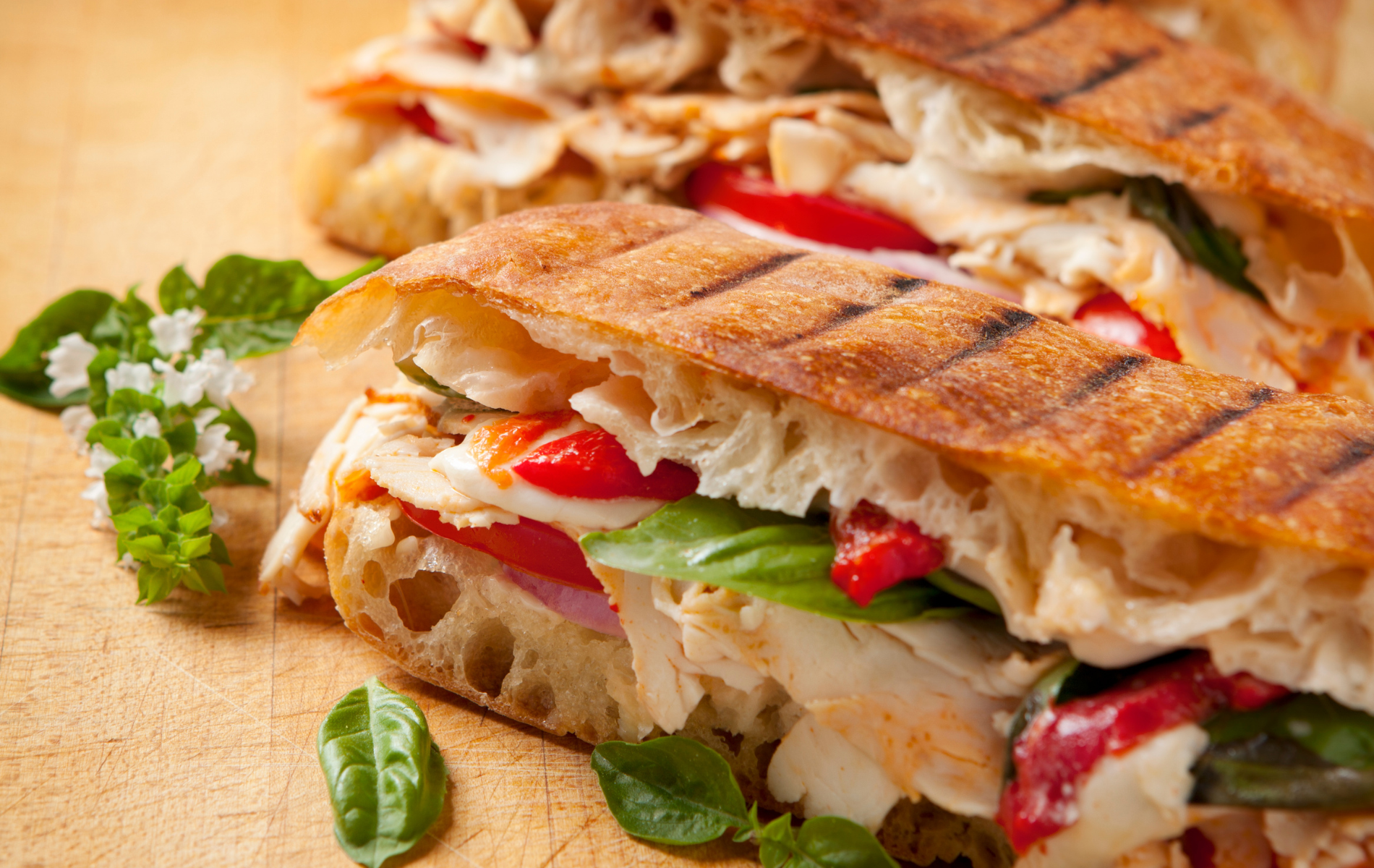 A close up of a panini sandwich on a wooden table.