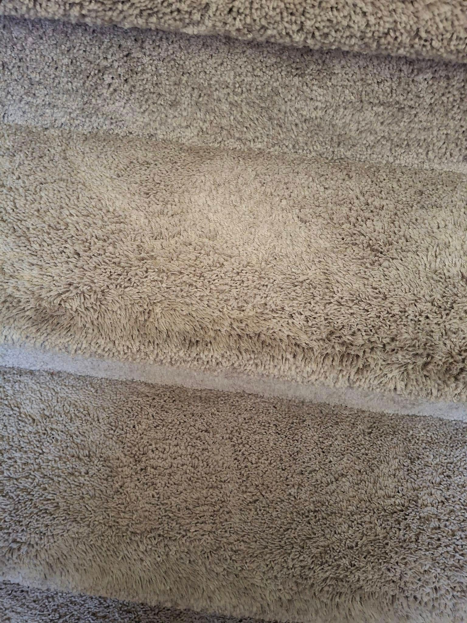 Tan, textured surface with horizontal, undulating lines; possibly fabric or wall.