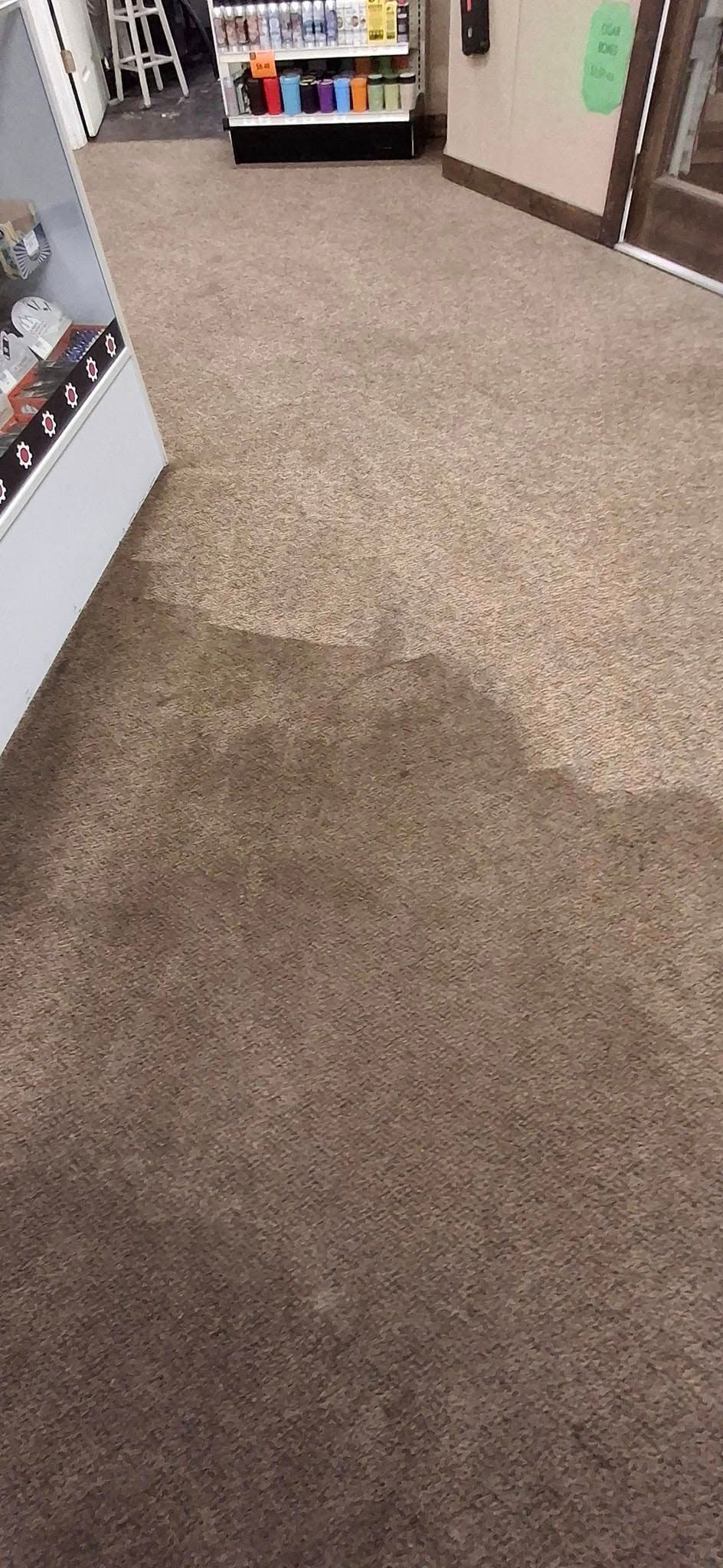 A carpeted retail store with shelves of products.