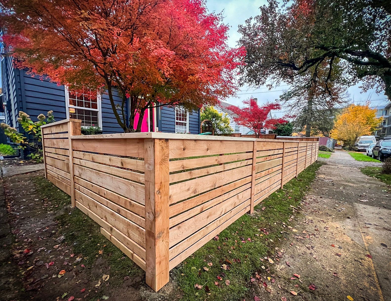 Black chain-link fence with a black top rail, viewed from a close, angled perspective, outdoors.