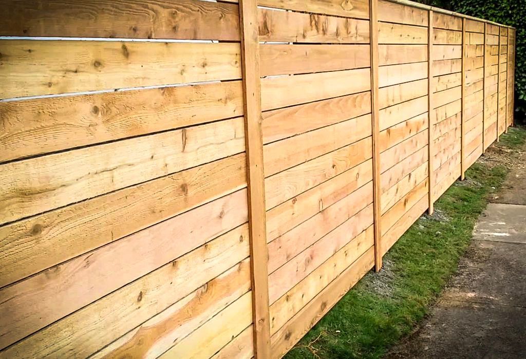 Wooden privacy fence in horizontal plank design.