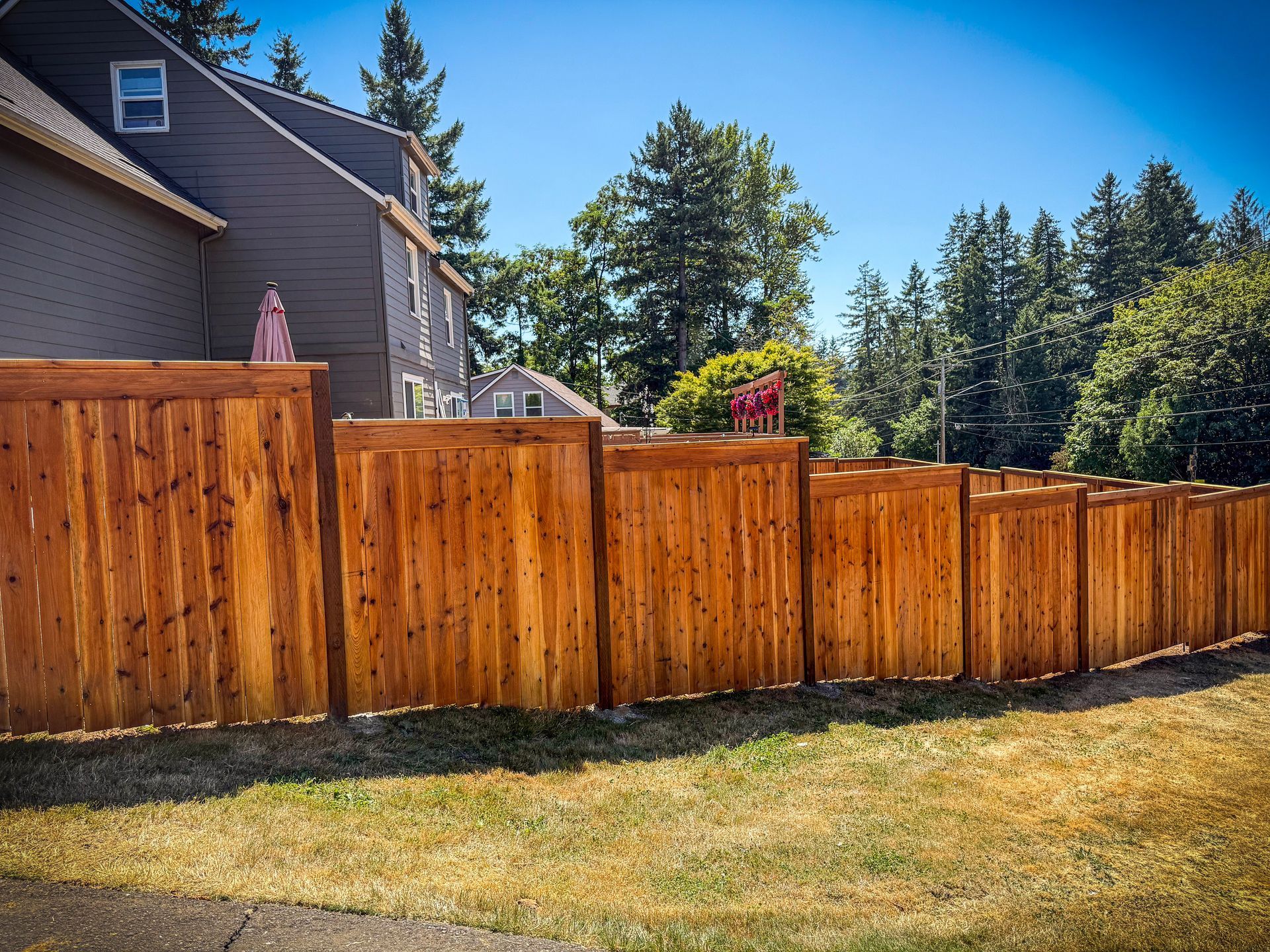 Black chain-link fence with a black top rail, viewed from a close, angled perspective, outdoors.