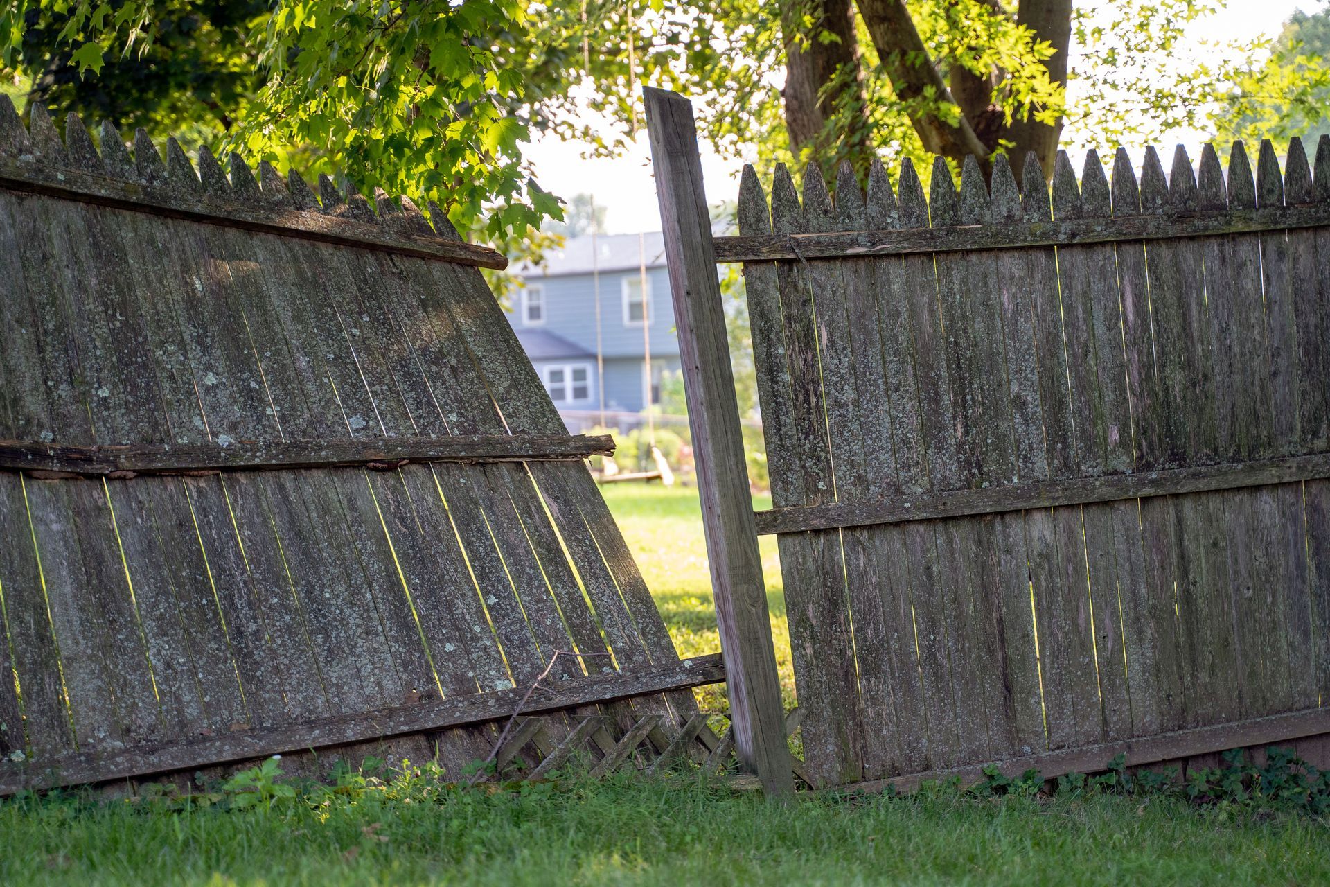 Black chain-link fence with a black top rail, viewed from a close, angled perspective, outdoors.