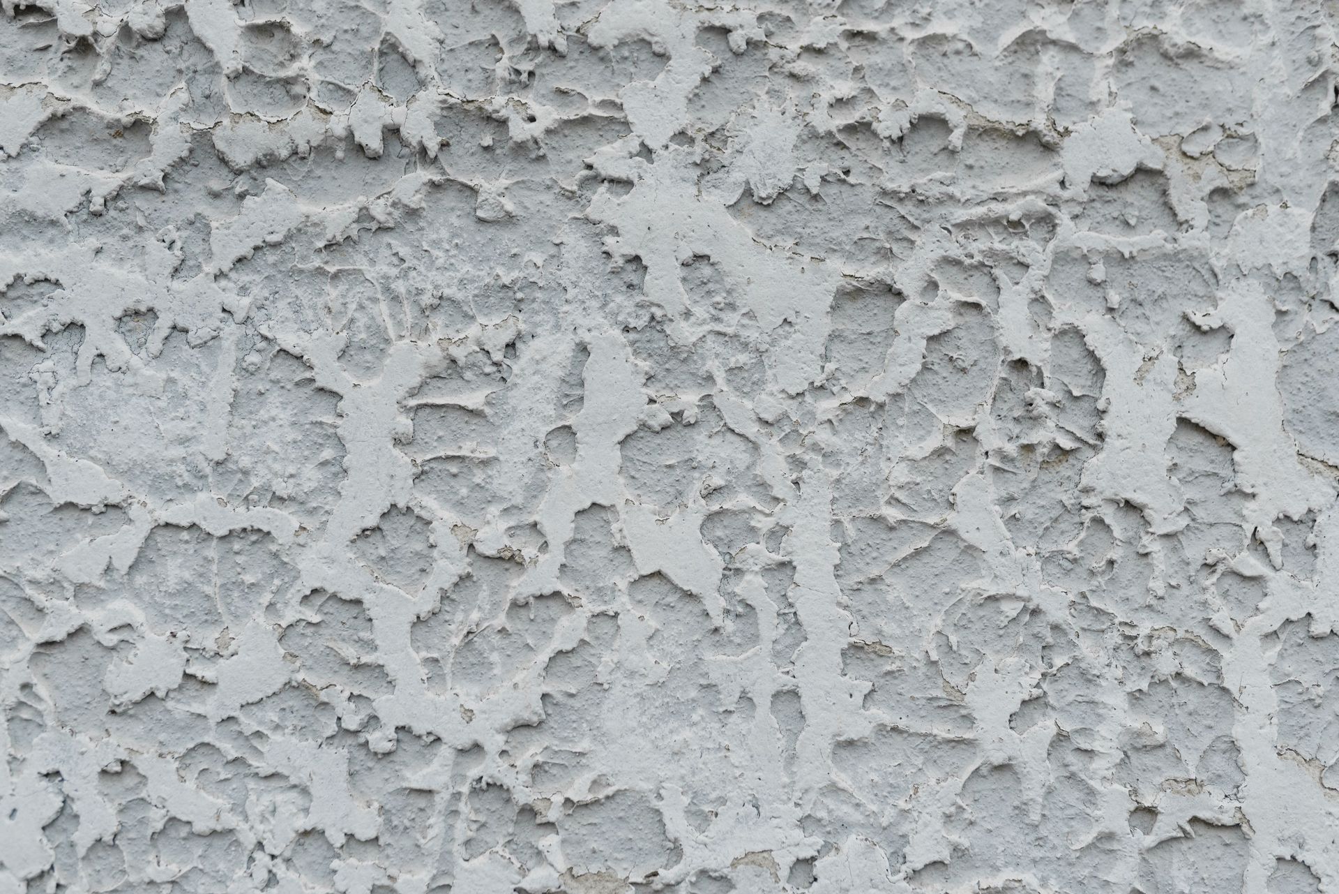 Close-up of a light gray textured stucco wall surface