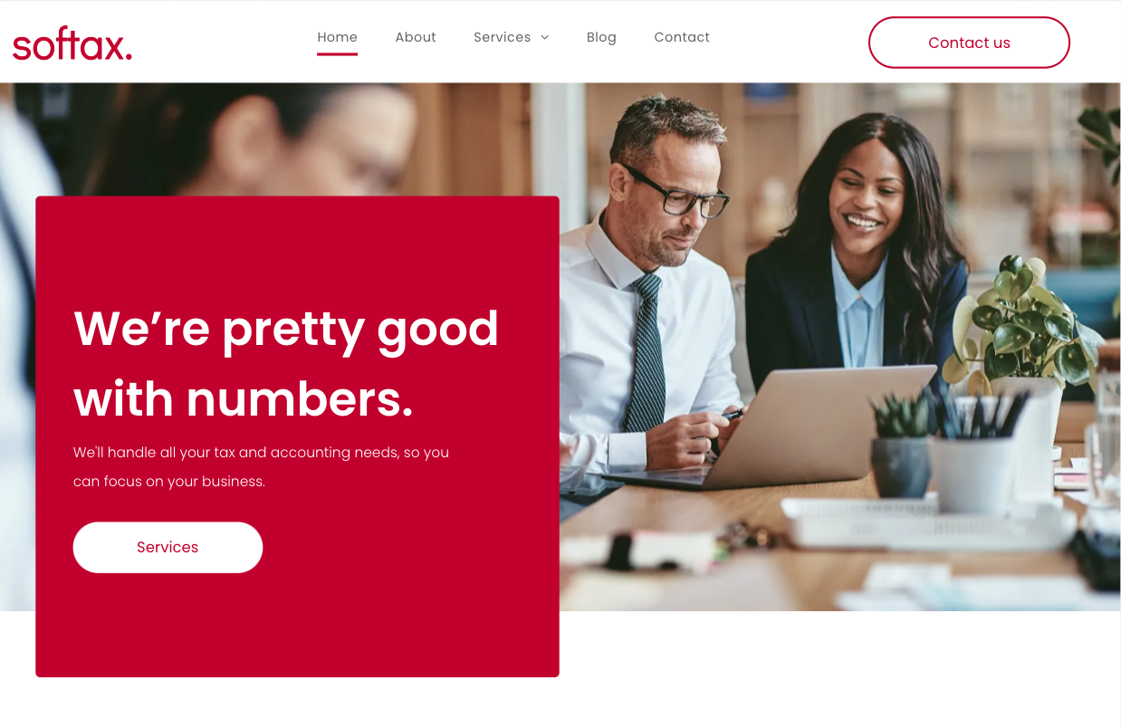 A man and a woman are sitting at a table looking at a laptop computer.