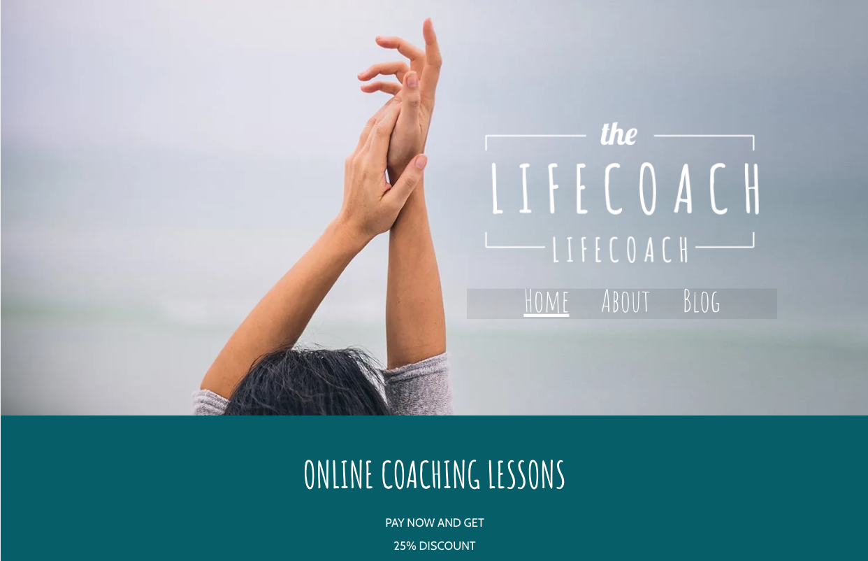 A woman is holding her hands up in the air in front of the ocean.