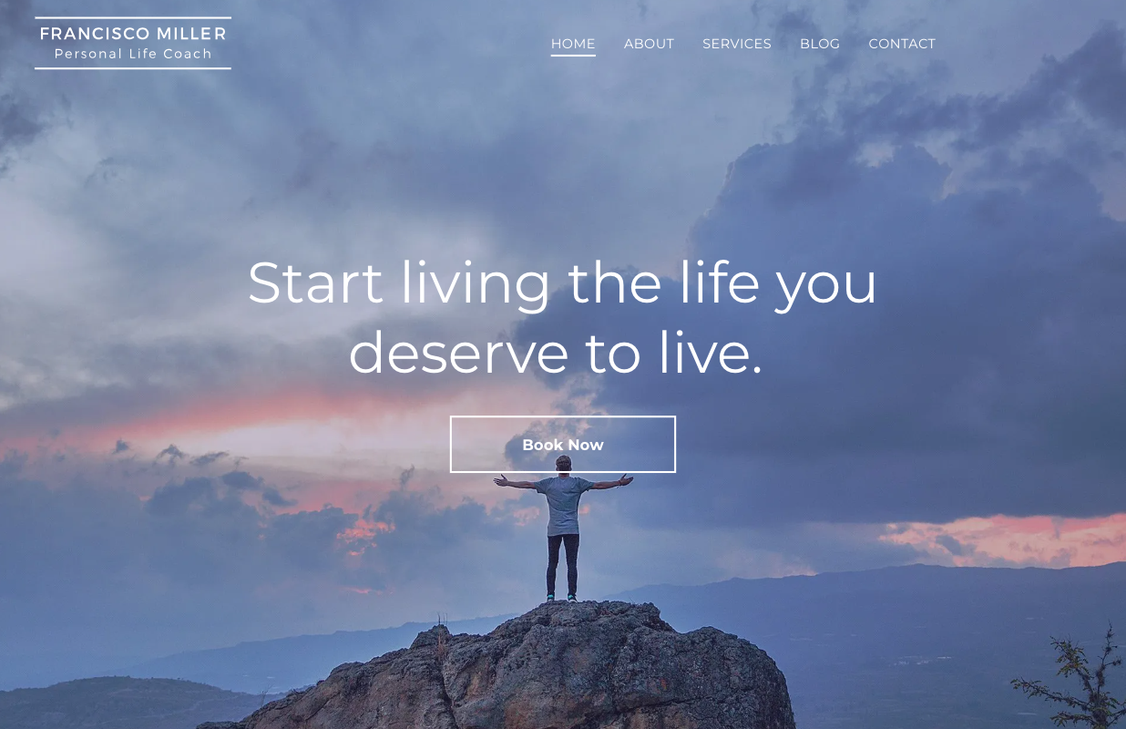 A man is standing on top of a rock with his arms outstretched.