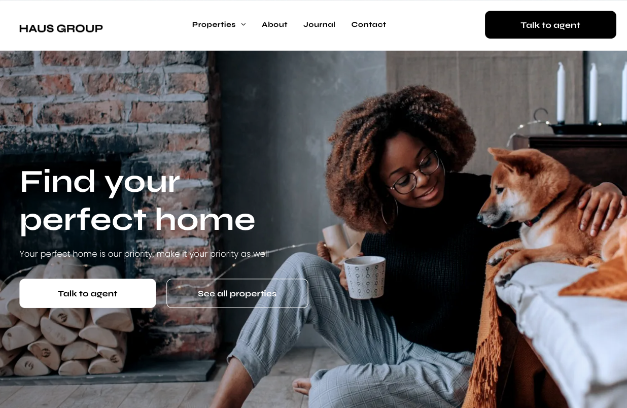 A woman is sitting on the floor with a dog and a cup of coffee.