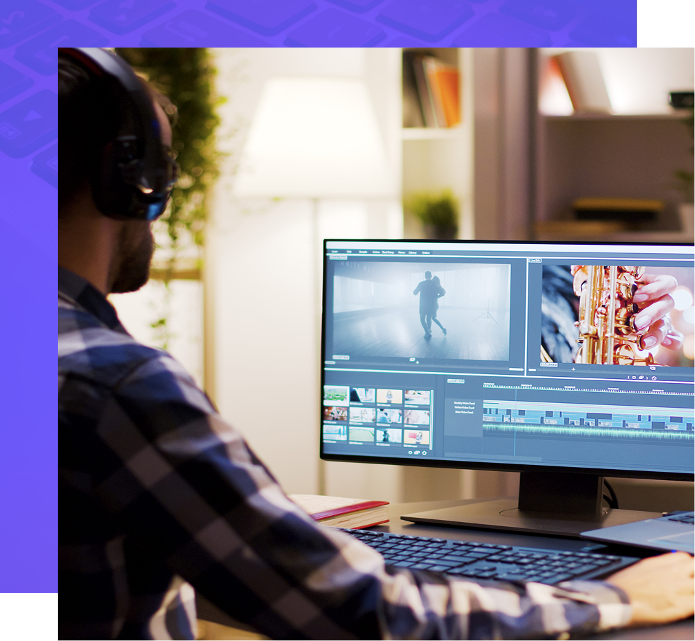 A person wearing headphones edits video on a computer at a desk.