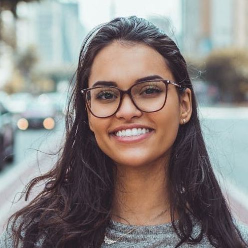 A woman wearing glasses is smiling for the camera.